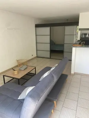 a living room with a large bed and a table at Spacieux 2 chambres, CLIM, parking prive ferme, LOCAL VELOS in Entraigues-sur-la-Sorgue