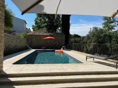 a swimming pool with a red umbrella and a red raft at Villa luxueuse à Ménerbes + piscine in Ménerbes