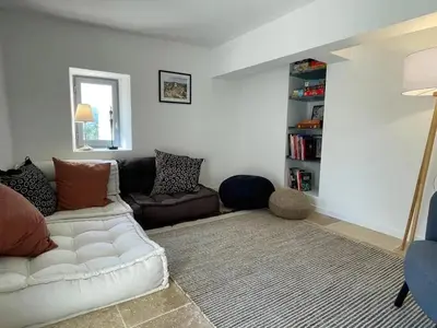 a living room with a white couch and a book shelf at Villa luxueuse à Ménerbes + piscine in Ménerbes