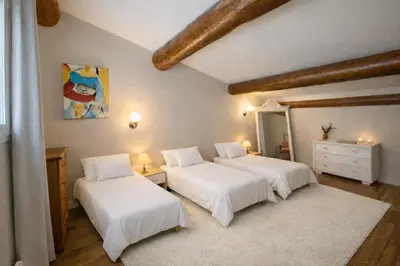 two beds in a room with white sheets at Villa Mireyos in Rognes