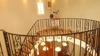 a spiral staircase with a chandelier at Villa spacieuse à Cavaillon avec piscine privée in Cavaillon
