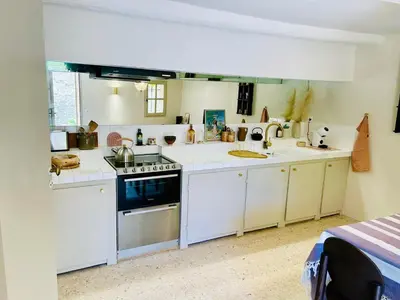a kitchen with white cabinets and a stove and sink at Maison Joucas in Joucas