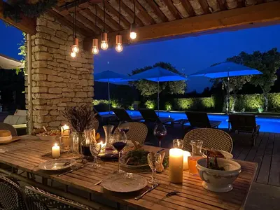 a wooden table with candles and wine glasses at La maison de Inna in Bonnieux