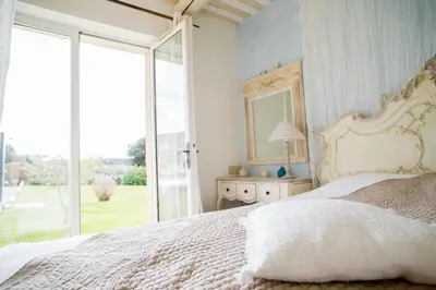 a bedroom with a bed with a mirror and a window at La maison de Inna in Bonnieux