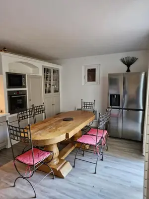 a kitchen with a wooden table and pink chairs at Maison avec piscine privée, sauna et activités - Rendez-vous en Provence in Althen-des-Paluds