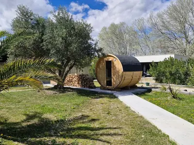 a round wooden building in a yard with a tree at Maison avec piscine privée, sauna et activités - Rendez-vous en Provence in Althen-des-Paluds