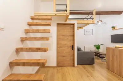 a wooden staircase in a living room with a sliding door at Studio Aixois Mezzanine in Aix-en-Provence