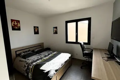 a bedroom with a bed and a desk and a window at Chez Céline - Belle maison climatisée piscine in Carpentras