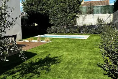 a backyard with a swimming pool and a grass yard at Chez Céline - Belle maison climatisée piscine in Carpentras
