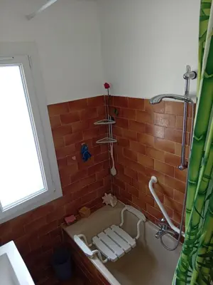 a bathroom with a bath tub with a brick wall at T3 campagne Aix-en-Provence in Meyrargues