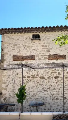 a brick building with signs on the side of it at Gîte de l'Escanson un temps pour soi in Robion en Luberon