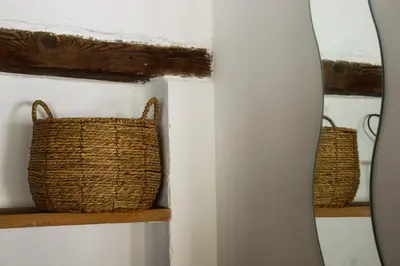 a bathroom with two baskets and a mirror at Gîte de l'Escanson un temps pour soi in Robion en Luberon