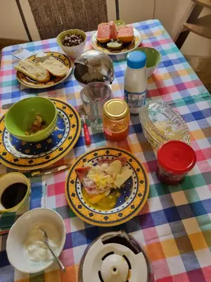 a table with plates of food on a colorful table cloth at Gîte de l'Escanson un temps pour soi in Robion en Luberon