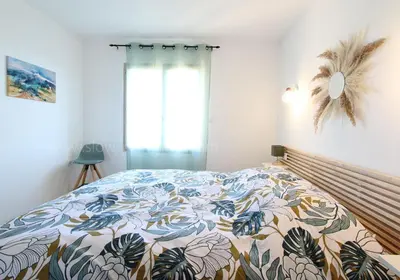 a bedroom with a bed with a colorful comforter at La maison des cerisiers in Bédoin