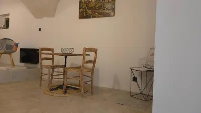 a room with a table and chairs and a tv at Petit bonheur in Lauris