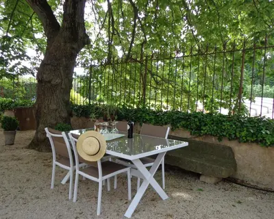 a white table and chairs under a tree at Domaine Les Rivales in Cavaillon