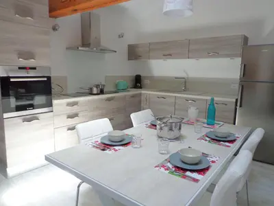 a kitchen with a white table and white chairs at Domaine Les Rivales in Cavaillon