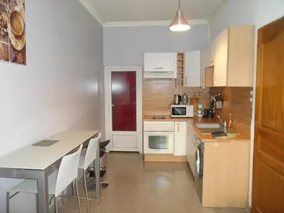 a kitchen with white cabinets and a table at Appartement 2 pieces centre ville in Salon-de-Provence