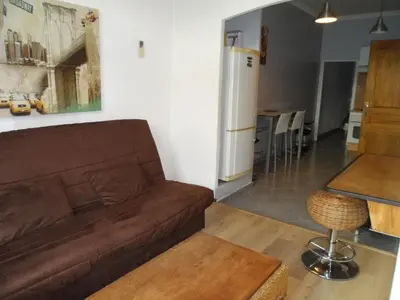 a living room with a brown couch and a kitchen at Appartement 2 pieces centre ville in Salon-de-Provence
