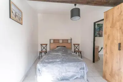 a bedroom with a bed and two chairs in it at Appartement moderne à L'Isle-sur-la-Sorgue, 50 m² avec parking. in LʼIsle-sur-la-Sorgue