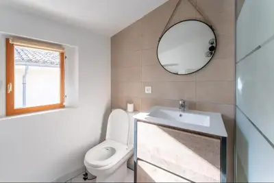 a bathroom with a toilet and a sink and a mirror at Appartement moderne à L'Isle-sur-la-Sorgue, 50 m² avec parking. in LʼIsle-sur-la-Sorgue
