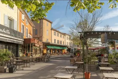 an empty street with tables and chairs and buildings at Appartement moderne à L'Isle-sur-la-Sorgue, 50 m² avec parking. in LʼIsle-sur-la-Sorgue