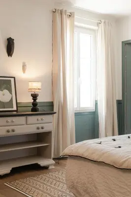 a bedroom with a bed and a dresser with a window at LE MAS DE LA TERRE - Chambres d'hôtes in LʼIsle-sur-la-Sorgue