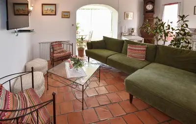 a living room with a green couch and a table at Beautiful Home In La Bastide-Des-Jourdan in La Bastide-des-Jourdans