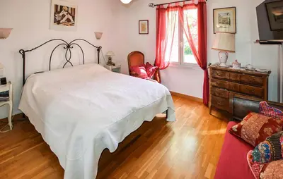 a bedroom with a bed and a dresser and a window at Beautiful Home In La Bastide-Des-Jourdan in La Bastide-des-Jourdans