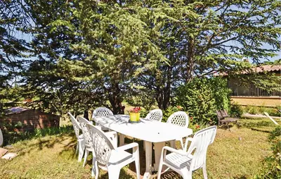 a white table and chairs in a yard at Beautiful Home In La Bastide-Des-Jourdan in La Bastide-des-Jourdans