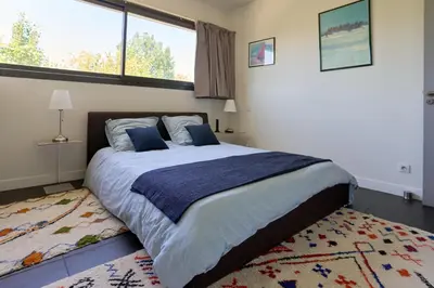 a bedroom with a large bed and a large window at Sérénité au fil de l'eau Appartement de standing in LʼIsle-sur-la-Sorgue