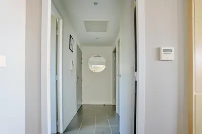 a hallway with white walls and a white hallway at Sérénité au fil de l'eau Appartement de standing in LʼIsle-sur-la-Sorgue