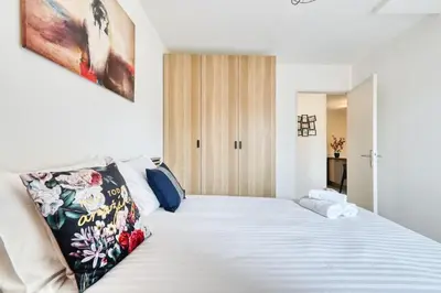 a bedroom with a large bed with white sheets at appartement idéalement situé sur aix en provence in Aix-en-Provence