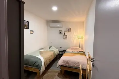 two beds in a small room with a hallway at Très bel appartement climatisé - Chez Tom et Anna in Bédoin