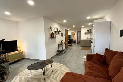 a living room with a couch and a kitchen at Très bel appartement climatisé - Chez Tom et Anna in Bédoin