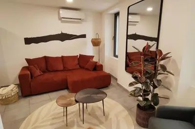 a living room with a red couch and a table at Très bel appartement climatisé - Chez Tom et Anna in Bédoin