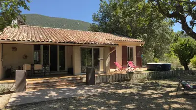 a small house with two chairs on a patio at Odette du Colorado, vue sur le colorado, jacuzzi, boisé in Rustrel