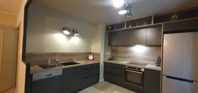 a kitchen with gray cabinets and a sink and a refrigerator at Odette du Colorado, vue sur le colorado, jacuzzi, boisé in Rustrel