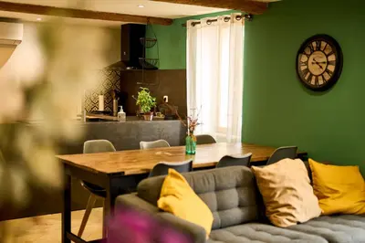 a living room with a couch and a table and a clock at Maison avec jardin in Pernes-les-Fontaines