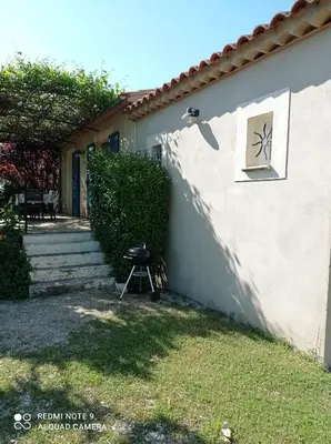 a side of a house with a grill in the yard at Le Cabanon d'Amandine et Gabriel in Blauvac