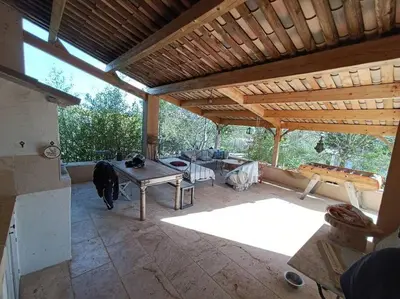 a covered patio with a table and a wooden roof at Villa Reillanne Luberon in Reillanne
