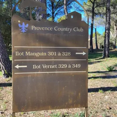 a sign for the powerhouse country club in a park at La Calade in LʼIsle-sur-la-Sorgue