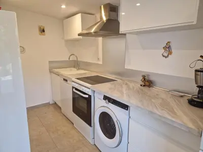 a kitchen with a washing machine and a sink at la Cigalière in LʼIsle-sur-la-Sorgue