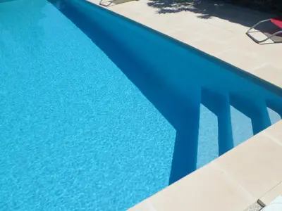 a pool with a blue table and chairs next to it at Clos Sainte-Garde in Saint-Didier