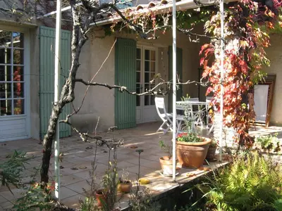 a porch of a house with a table and a chair at Clos Sainte-Garde in Saint-Didier