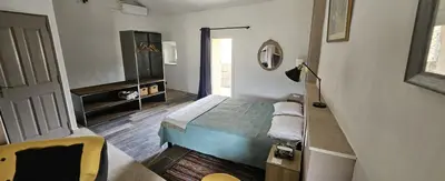 a bedroom with a bed and a mirror and a door at maison O jasmin in Lagnes
