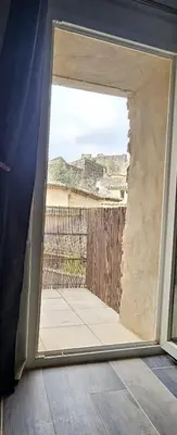 an open door with a view of a balcony at maison O jasmin in Lagnes