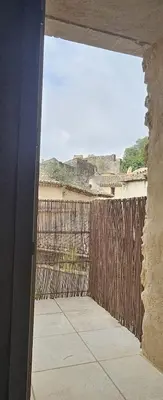 a room with a fence and a view of the beach at maison O jasmin in Lagnes