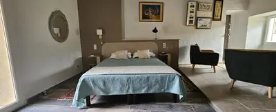 a bedroom with a bed and a chair at maison O jasmin in Lagnes