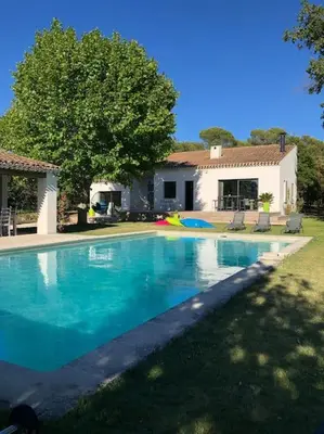 a large blue swimming pool in front of a house at Proche Aix-en-Provence maison avec piscine - 10 personnes in Rognes